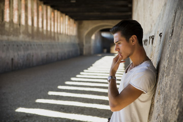 Wall Mural - Handsome young man in old building against brick wall