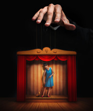 Male Hand Controlling A Small Woman Puppet