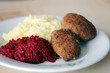 Pork chops with beetroot and potatoes on a white plate