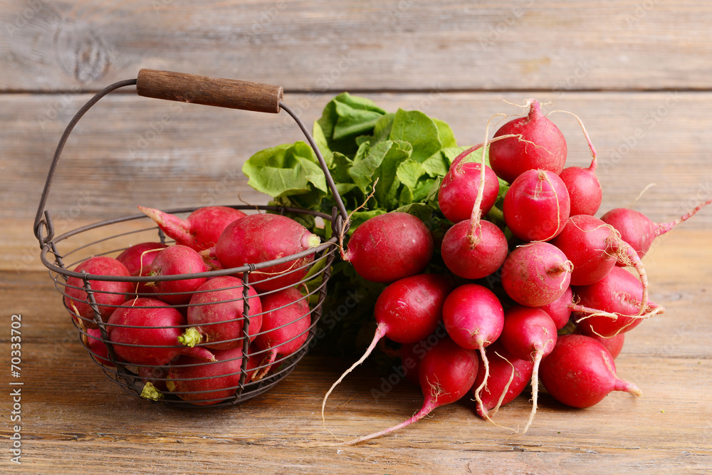 Radish in wicker basket on wooden background