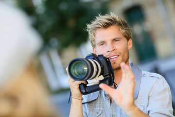 Young photographer shooting model outside