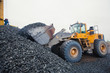 © tsuguliev - Yellow heavy excavator and bulldozer unloading road metal during