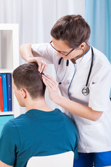 Wall Mural - Doctor inspecting skin of head