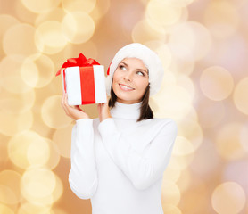 Wall Mural - smiling woman in santa helper hat with gift box