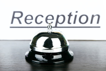 Reception bell on desk, on bright background