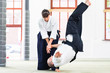 Aikido Lehrer und Schüler trainieren Werfen 
