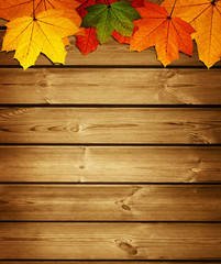 wooden background with autumn maple leaves