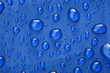 Closeup of rain drops on a blue umbrella