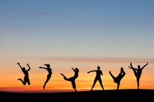 Silhouetted Group Tumbling And Dancing In Sunset