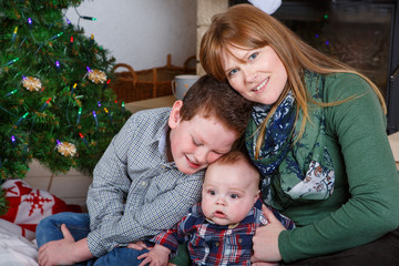 Beautiful young mother and two adorable sibling boys with Christ