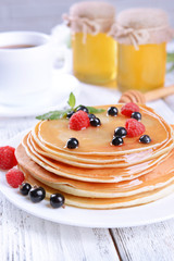 Wall Mural - Sweet pancakes with berries on table close-up