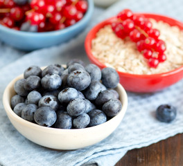 Wall Mural - Blueberries, red currants nad cereals in bowls