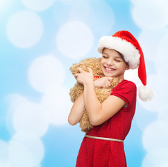 Canvas Print - smiling girl in santa helper hat with teddy bear