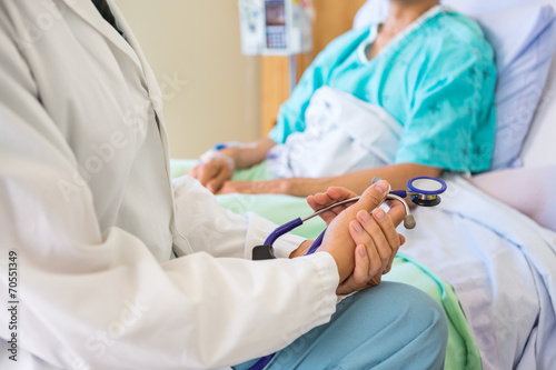 Fotografía Female Doctor Sitting With Patient On Hospital Bed