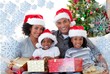 © WavebreakMediaMicro - Composite image of family holding christmas presents