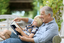 Grandfather Reading Book With Grandson