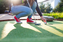 Young Woman Plays Adventure/mini Golf In Summer Evening