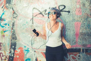 young beautiful short blue hair hipster woman with headphones mu