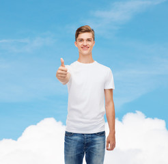 Wall Mural - smiling man in white t-shirt showing thumbs up