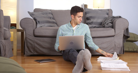 Wall Mural - Mexican businessman working at home on floor