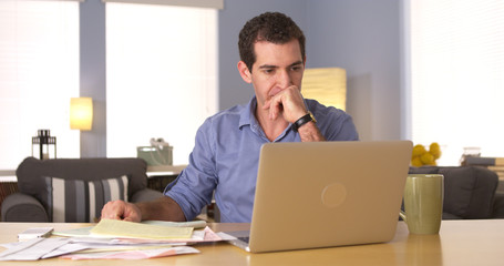 Young man paying bills at home