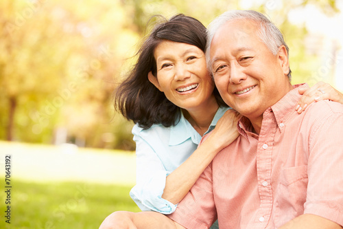 Foto Portrait Of Senior Asian Couple Sitting In Park Together