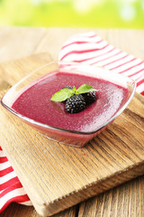 Wall Mural - Delicious berry mousse in bowl on table close-up