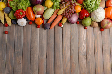 Fresh organic fruits and vegetables on wooden background