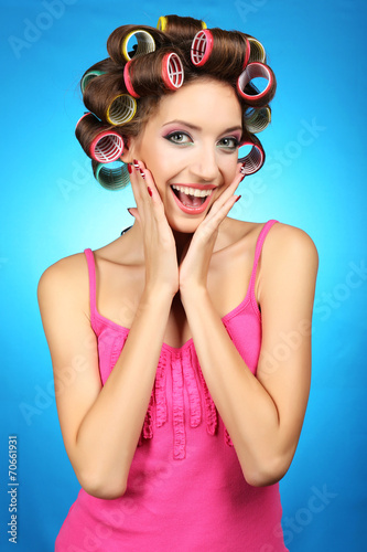Fototapeta dla dzieci Beautiful girl in hair curlers on blue background