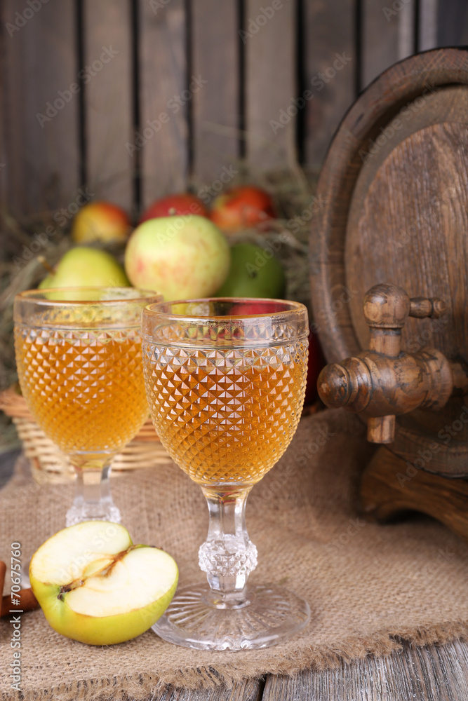 Still life with tasty apple cider in barrel and fresh apples