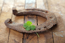 Old Horse Shoe,with Clover Leaf, On Wooden Background