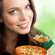 Woman eating muesli or cornflakes, outdoor