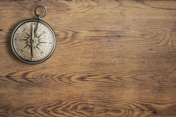 Poster - old compass on vintage wooden table top view