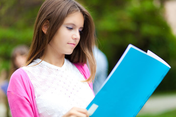 Student reading a book at the park