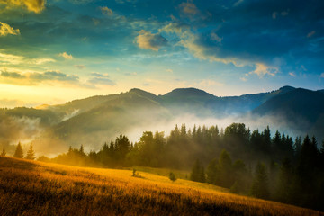 Wall Mural - amazing mountain landscape with fog and a haystack