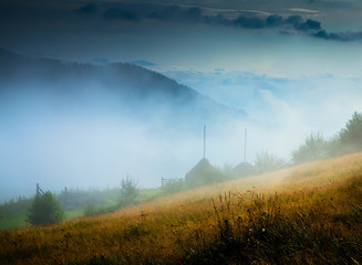 Wall Mural - amazing mountain landscape with fog and a haystack