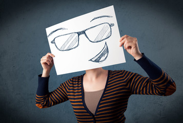 Wall Mural - Woman holding a paper with smiley face in front of her head