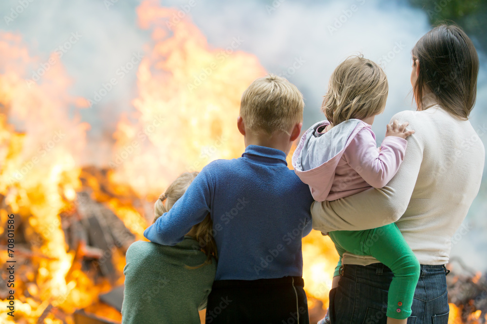 Family mother with children at burning house background - obrazy, fototapety, plakaty 