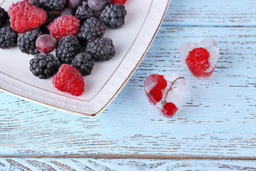 Wall Mural - Ice cubes with red currant and frozen forest berries