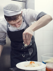 Wall Mural - chef preparing food in the kitchen at the restaurant