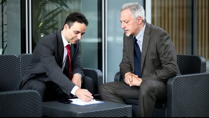 Canvas Print - People talking together while reading business documents