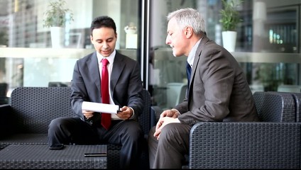 Canvas Print - Business people talking while reading business documents