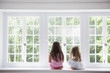 © Mint Images - Two girls sitting by large window