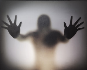 Man standing behind frosted glass