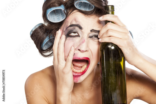 Cuadros en Lienzo Borracho mujer joven con rulos llorando al lado de una botella de vino