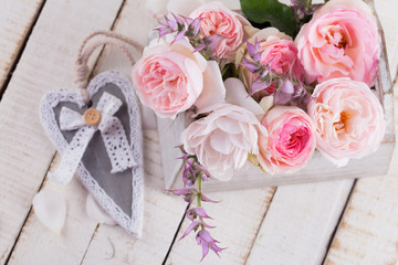 Wall Mural - Fresh roses in box on white wooden background.