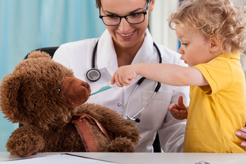 Wall Mural - Child taking temperature of teddy bear