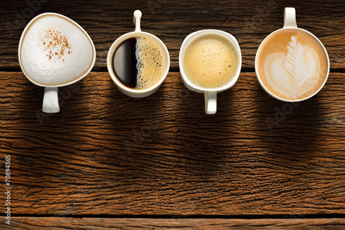 Naklejka ścienna Variety of cups of coffee on old wooden table