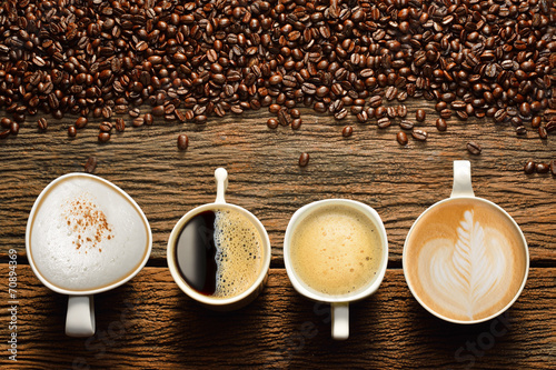 Tapeta ścienna na wymiar Variety of cups of coffee and coffee beans on old wooden table