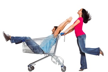 Young couple having fun with shopping cart